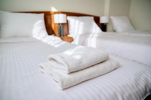 two white towels are stacked on a bed at Forrest in Głogów Małopolski