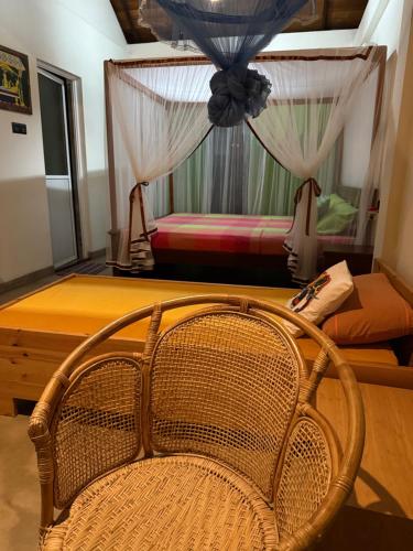 a rattan chair in a room with two beds at Victoria House by Srilanka Tripper in Kandy