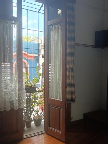an open door to a balcony with potted plants at Tu casa en Montevideo in Montevideo