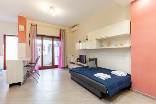 a bedroom with a bed and a desk and a television at Il Vascello by ACS HOLIDAYS in Lido di Ostia