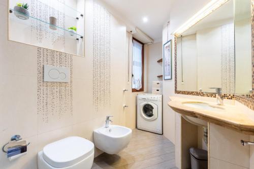 a bathroom with a toilet and a sink and a washing machine at Il Vascello by ACS HOLIDAYS in Lido di Ostia