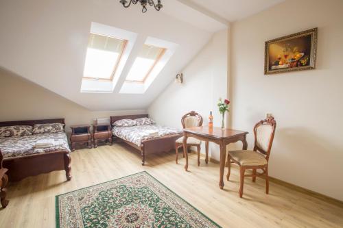 a attic room with a table and chairs and a couch at Dworek Stara Szkoła in Bełchatów