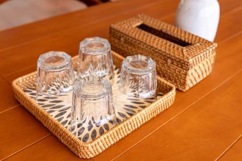 a tray with three glasses and a box on a table at Amaya Kampot Homestays in Kampot