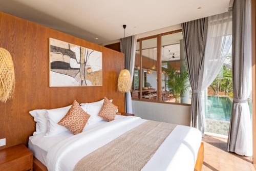 a bedroom with a large bed and a large window at Amaya Kampot Homestays in Kampot