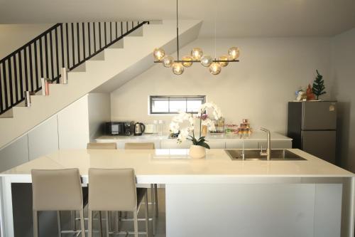 a kitchen with a counter with a sink and a staircase at BAAN BIBI near Saturday walking street in Chiang Mai