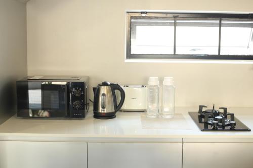a kitchen counter with a microwave and a coffee maker at BAAN BIBI near Saturday walking street in Chiang Mai