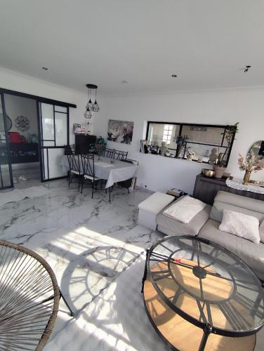 Arnouville-lès-GonesseにあるMaison Meublée 4 chambres proche aéroports Bourget et Roissy CDG et Salon des expositions Villepinteのソファとテーブルのあるリビングルーム