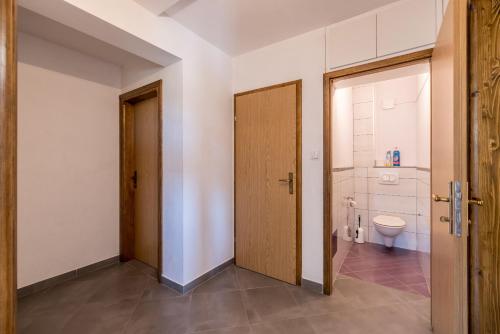 an empty bathroom with a toilet and a door at Vila Nina - Apartment Valentina in Vinišće