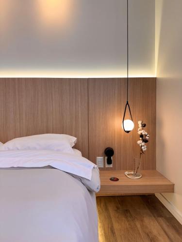 a bedroom with a white bed and a wooden headboard at Cobertura Amanhecer em Dois Irmãos in Dois Irmãos