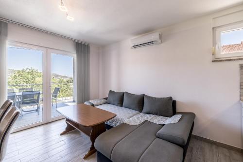 a living room with a couch and a table at Vila Nina - Apartment Valentina in Vinišće