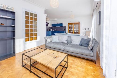 un salon avec un canapé et une table basse dans l'établissement Grand Appartement de Coubertin - Calme - Albi, à Albi