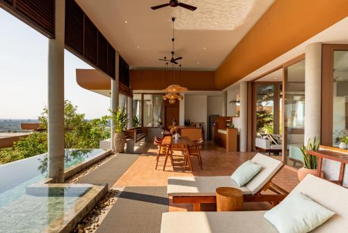 an open living room and dining room with a view of a house at Amaya Kampot Homestays in Kampot