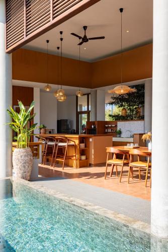 an open kitchen and dining area with a pool in a house at Amaya Kampot Homestays in Kampot