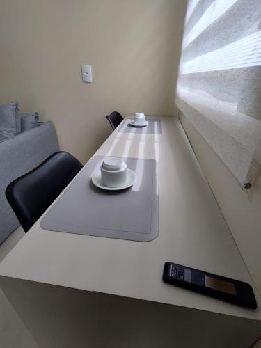 a table with a plate and a remote control on it at Kitnet 01 familiar individual in Palmas