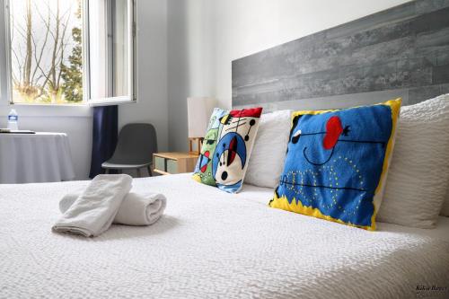 a bedroom with a bed with pillows on it at Hôtel Restaurant La Plage in Saint-Louis-du-Rhône