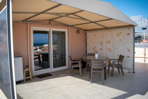une tente avec une table et des chaises sur une terrasse dans l'établissement Roof Top, à Chios