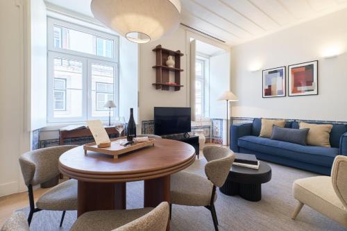 a living room with a table and a blue couch at Ando Living - Santa Justa 79 House in Lisbon