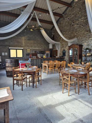 un restaurant avec des tables et des chaises en bois ainsi qu'un bar dans l'établissement Le Family Cottage du Brask, à La Motte-du-Caire
