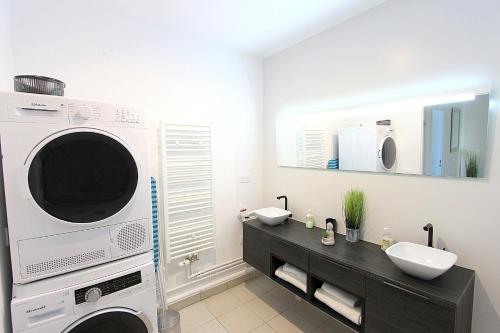 une salle de bain avec une machine à laver et un lavabo dans l'établissement TERA2 - Charme de Disneyland Paris Vallée Village, à Serris