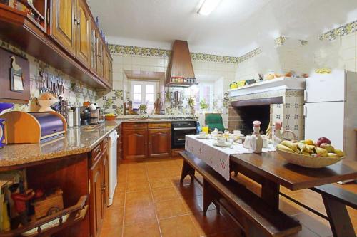a kitchen with a table with a bowl of fruit on it at Monte do Parral in Santiago do Cacém