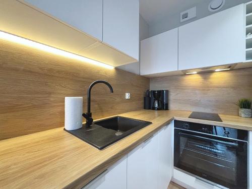 a kitchen with a sink and a stove at Sun Towers - Apartamenty Bryza - Apartamenty z parkingiem in Świnoujście