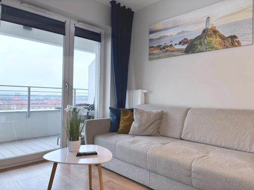 a living room with a couch and a table at Sun Towers - Apartamenty Bryza - Apartamenty z parkingiem in Świnoujście