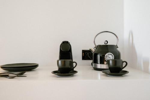 a tea kettle and two cups on a counter at Gazelle Living in Imerovigli