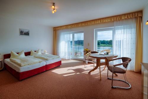 德紹的住宿－布拉姆巴赫埃布特拉森酒店，一间卧室配有一张床铺和一张桌子,还有一间用餐室