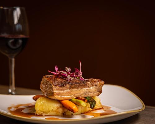 a plate of food with a piece of meat and vegetables at Holiday Inn London West by IHG in London