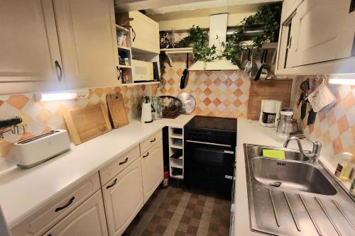 une petite cuisine avec un évier et une cuisinière dans l'établissement Spacious house just steps from the beach, à Villerville