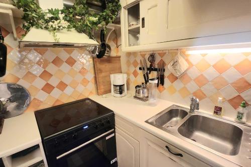 une petite cuisine avec un évier et une cuisinière dans l'établissement Spacious house just steps from the beach, à Villerville