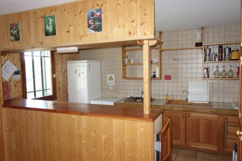 une cuisine avec des armoires en bois et un réfrigérateur blanc dans l'établissement Chalet d'alpage du Cubertin - Préalpes de Digne, à Auzet