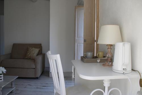 a living room with a white table and a chair at La Casa della Filanda in Belmonte Calabro