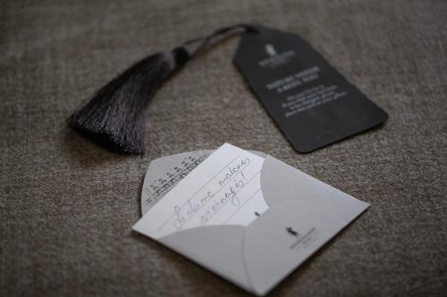 a black tie and two pieces of paper on a table at Michaelson Boutique Hotel & SPA Brícoła in Klaipėda