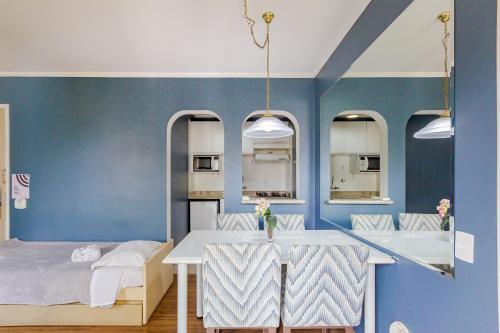 a room with a bed and a table and some mirrors at Paulista Flat in São Paulo
