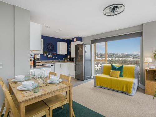 a kitchen and dining room with a table and a yellow chair at Luxury Loft Living Free Parking - Pass the Keys in Brighton & Hove
