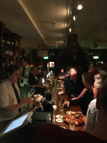 a group of people sitting at a long bar at Beach Hotel Katwijk in Katwijk