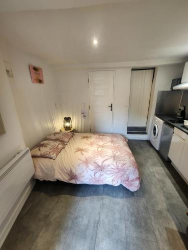a small bedroom with a bed and a kitchen at Parfum mimosa in Grasse
