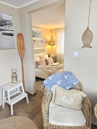 a living room with a wicker chair and a bedroom at Beach House in Międzyzdroje