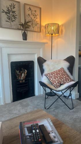 a living room with a chair and a fireplace at Charming 2B Georgian Flat in Historic Tring in Tring