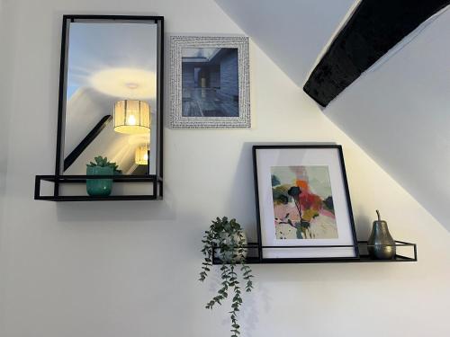 two mirrors on a wall with a picture and a plant at Charming 2B Georgian Flat in Historic Tring in Tring