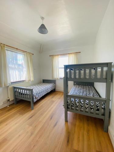 a bedroom with two beds and two windows at Lovely bed close to city center in Dublin
