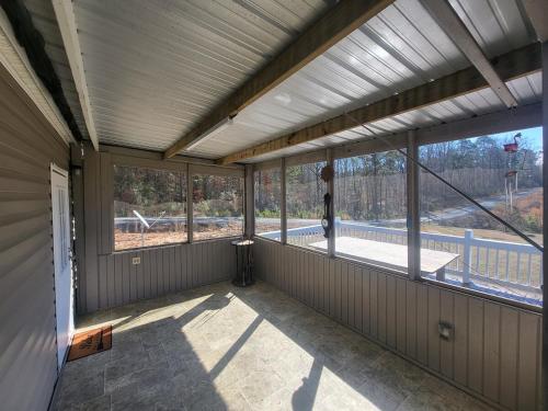 an empty screened in porch with large windows at The Tackle Box in Many