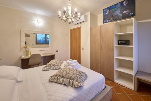 a bedroom with a bed and a desk and a chandelier at B&B Luci della Collina Boutique Relax in Tortoreto Lido