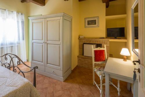 a bedroom with a white cabinet and a tv at Agriturismo I CASALI DI MORRO in Sellano