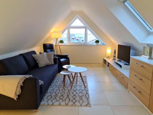 a living room with a couch and a tv at Fewo Grachtenhimmel- Appartement zum Entspannen in Krummhörn