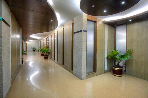 a hallway with potted plants in a building at FARS Hotel & Resorts - BAR-Buffet-Pool-SPA in Dhaka