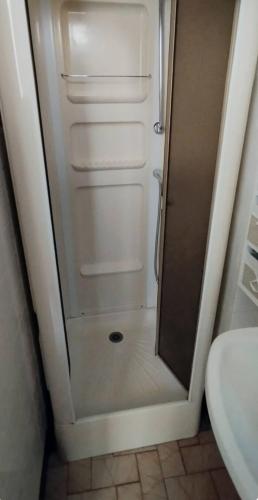 une petite salle de bain avec une douche avec la porte ouverte dans l'établissement Villa Mon Repos 1, à La Bourboule