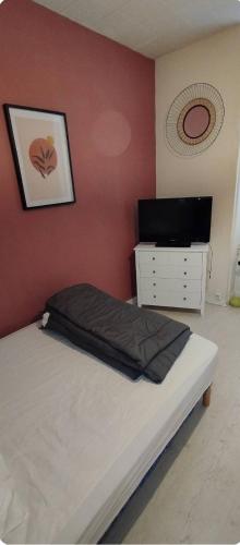 - une chambre avec un lit et une commode avec une photo sur le mur dans l'établissement Villa Mon Repos 1, à La Bourboule