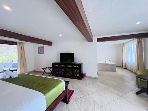 a bedroom with a bed and a tv in a room at Hotel Las Puertas de Tepoztlan in Tepoztlán